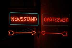 Neon Newsstand With Arrow And Reflection By Garysfrp Via Istockphoto