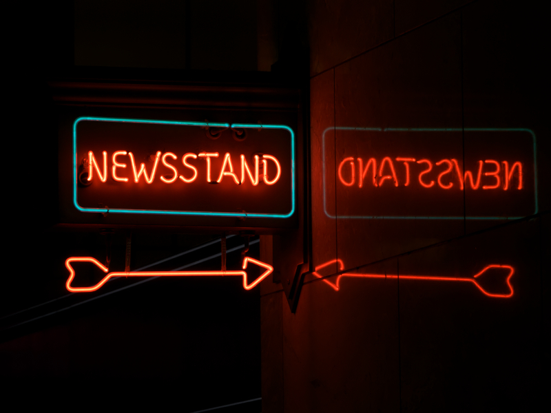 Neon Newsstand With Arrow And Reflection By Garysfrp Via Istockphoto