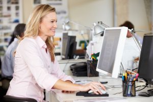 Woman working at desk in busy creative office by monkey business images via shutterstock