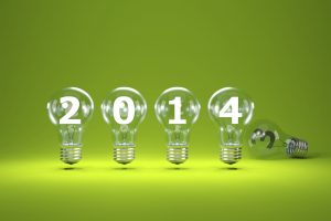 2014 New Year Sign Inside Light Bulbs On Green Background