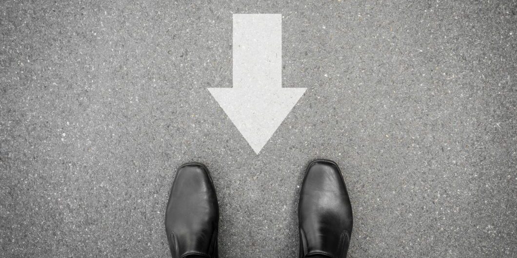 Black Shoes And Direction Sign Backward